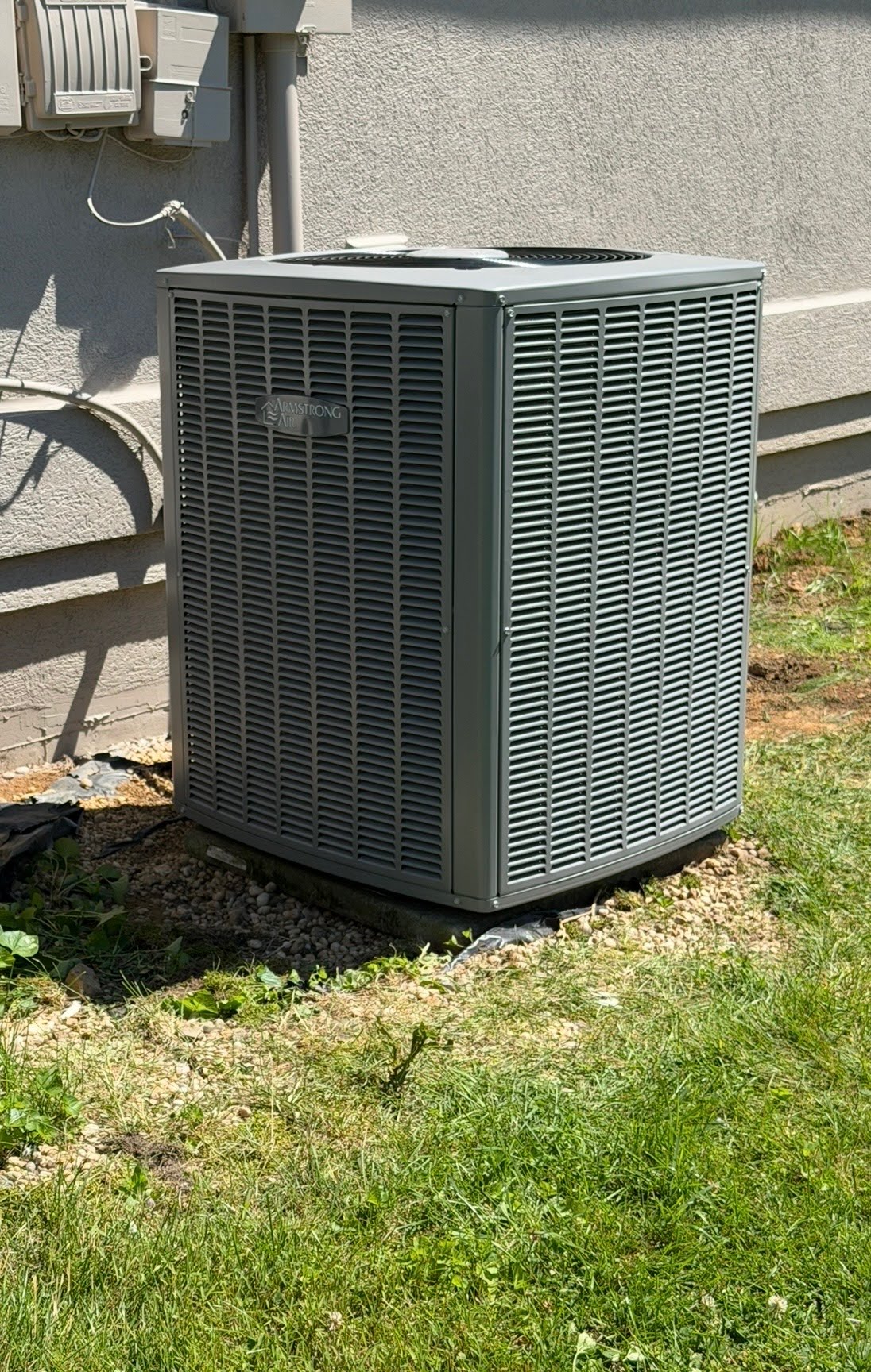 HVAC technician servicing an Armstrong air conditioning unit